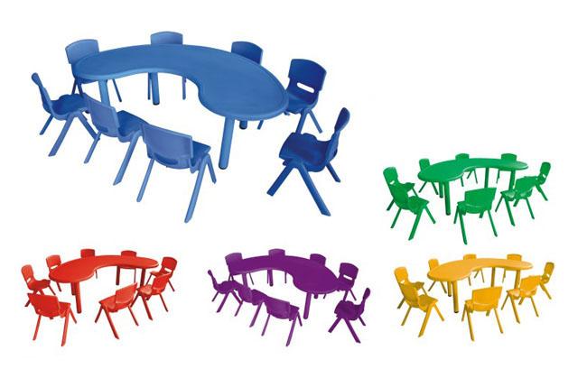 就学前の教室の家具、テーブルを学んでいる幼稚園の教室の家具の子供の半月のグループ